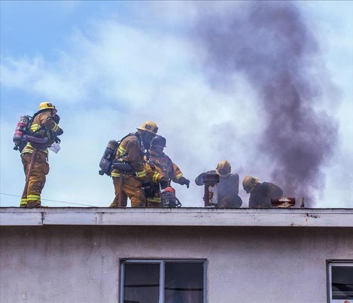 Firefighters working on a burning roof. 